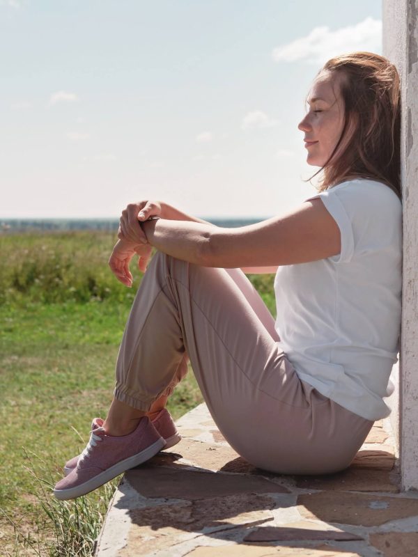 young-beautiful-woman-sitting-next-to-a-wall-and-enjoying-sea-scape-summer-holiday-1-1.jpg